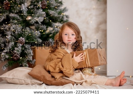 Cute, beautiful child girl at Christmas on the background of a decorated Christmas tree.