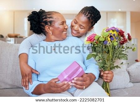 Black woman, mothers day and hug with flowers on sofa for love, box or gift to mom in home. Woman, bouquet and senior mama with wow, smile or happy for surprise, celebration or birthday on couch Royalty-Free Stock Photo #2225082701