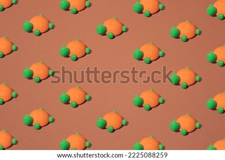 Orange green wooden turtle toy on a brown background. Minimal pattern. Copy space.