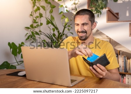 Man paying with credit card on laptop online shopping at home office.