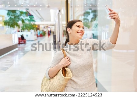 Happy young woman shopping taking selfie with smartphone for social media