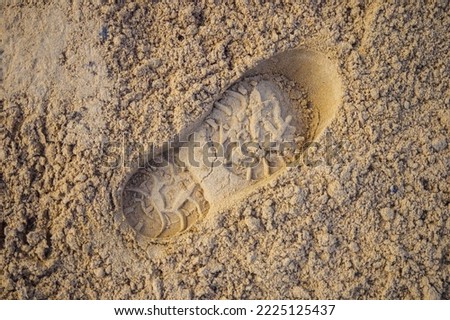 Single male footprint. Footprint from shoe or spade in sand. Background..
