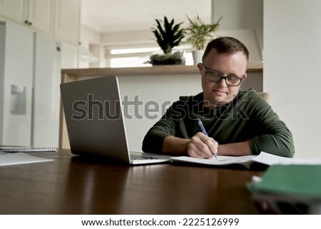 Man with down syndrome learning at home Royalty-Free Stock Photo #2225126999