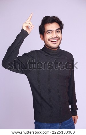 Pakistani man wearing knitted black sweater with turtle neck over isolated background showing and pointing up with finger number one while smiling confident and happy. Royalty-Free Stock Photo #2225133303