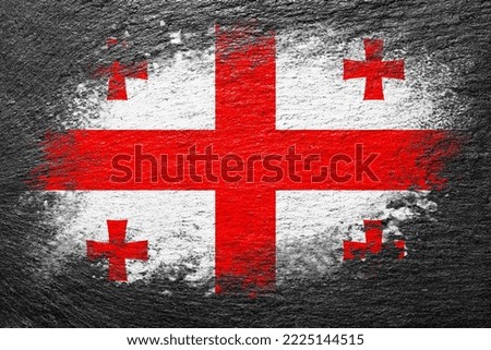 Flag of Georgia. Flag is painted on a stone surface. Stone background. Black slate background. Creative background