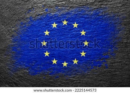 Flag of European Union. Flag is painted on a stone surface. Stone background. Black slate background. Creative background