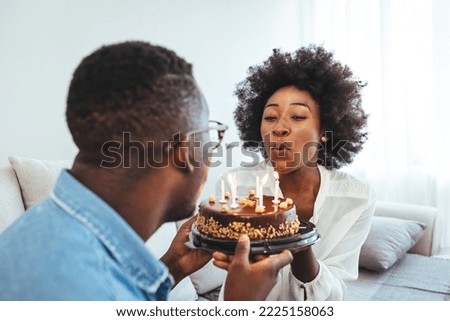 Young African American couple celebrating a private and simple birthday event at home. Shot of a young couple having cake while celebrating a birthday at home
