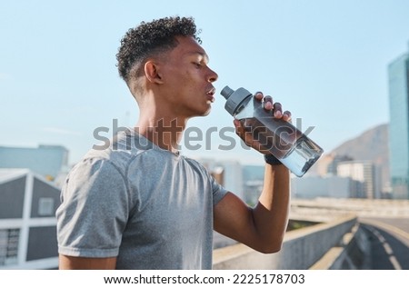 City, fitness and man drinking water after running in street, thirsty after workout in summer heat. Sun, exercise run and sweat, urban black man with healthy lifestyle and water bottle relax on road Royalty-Free Stock Photo #2225178703
