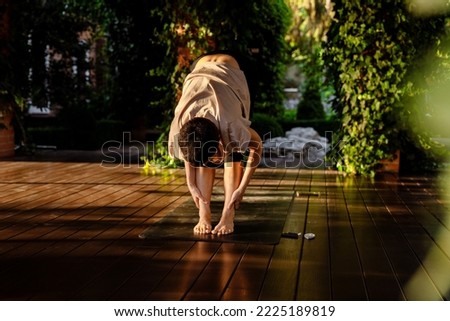 White brunette woman doing yoga stretches outdoors