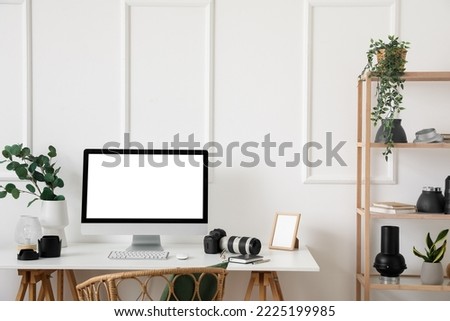 Photographer's workplace with computer and equipment in light office