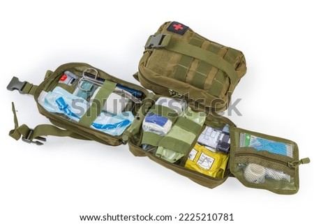 Open equipped military individual first aid kit with a content in the textile pouch and the same closed kit on a white background

