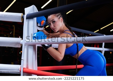 Beautiful and strong sportswoman posing in the corner of the ring. The concept of wrestling and boxing. Mixed media