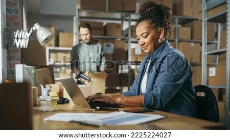 Diverse Male and Female Warehouse Inventory Managers Talking, Using Laptop Computer and Checking Retail Stock. Rows of Shelves Full of Cardboard Box Packages in the Background. Royalty-Free Stock Photo #2225224027