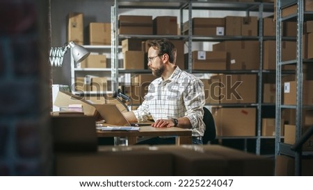 Male Inventory Manager Using Laptop Computer in Storeroom, Communicating with Clients, Writing Down Projects. Stylish Small Business Owner Working in Warehouse, Fulfilling Orders for Customers. Royalty-Free Stock Photo #2225224047