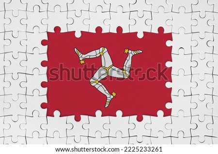 Isle of Man flag in frame of white puzzle pieces with missing central parts