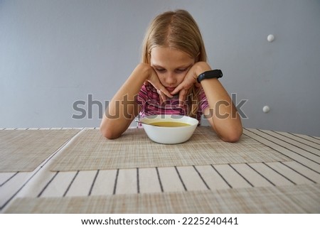 The girl at the table does not want to eat Royalty-Free Stock Photo #2225240441