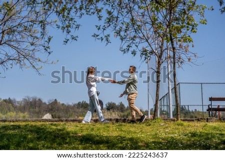 Happy romantic moments of lovely couple dancing and fooling around in park during dating