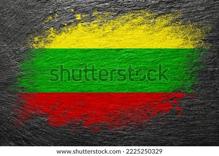 Flag of Lithuania. Flag is painted on a stone surface. Stone background. Black slate background. Creative background