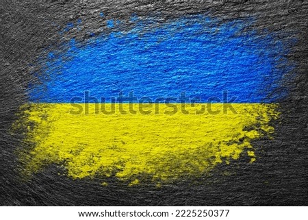 Flag of Ukraine. Flag is painted on a stone surface. Stone background. Black slate background. Creative background