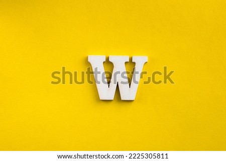 Alphabet letter W - White wood letter on yellow colored background Royalty-Free Stock Photo #2225305811