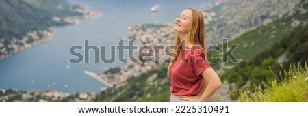 BANNER, LONG FORMAT Woman tourist enjoys the view of Kotor. Montenegro. Bay of Kotor, Gulf of Kotor, Boka Kotorska and walled old city. Travel to Montenegro concept. Fortifications of Kotor is on