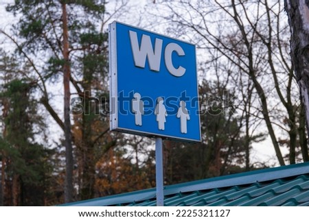 toilet signs he, she, they. blue sign on iron stick indicating the toilets. Modern men, women, they, public toilet. toilet sign