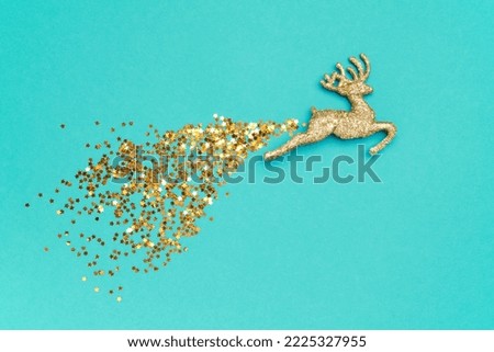 Wallpaper greeting card Merry Christmas holiday composition with golden toy ball deer glitter decoration on mint blue cyan background. Xmas New Year winter design idea concept. Top view, Flat lay. 