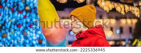 BANNER, LONG FORMAT Boy with cotton candy at christmas market. Happy child on Christmas market. Traditional leisure for families on xmas