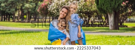BANNER, LONG FORMAT Ukrainian mother with two children with flag of Ukraine. Outside. Concept of problem of war in Europe, supporting of families and children, migrants, emigration, patriotism