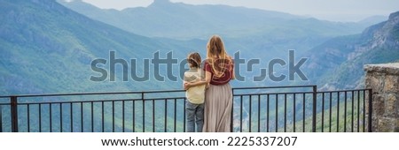 BANNER, LONG FORMAT Mother and son tourists on background of Blue river running through green valley toward distant mountains. Beautiful mountains of Montenegro and the river Cievna