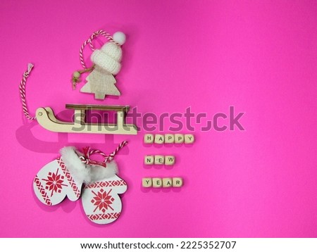 New Year's layout on a pink background, mittens, sled, with wooden Christmas trees. 2023 Happy New Year