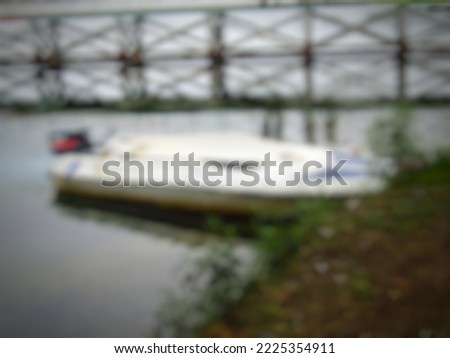 blurry, speed boat anchored by the lake