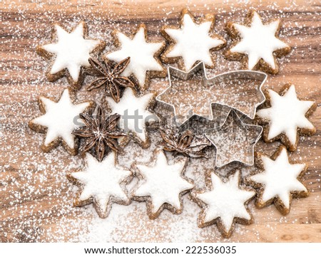 cinnamon stars and star anise on wooden background with sugar powder. christmas bakery. top view