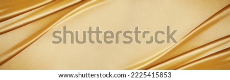 Golden silk satin. Luxury royal rich background with space for design. Soft folds. Shiny smooth fabric. Banner. Wide. Long.Panoramic.Anniversary, award, reward, Christmas, Birthday, wedding. Template. Royalty-Free Stock Photo #2225415853