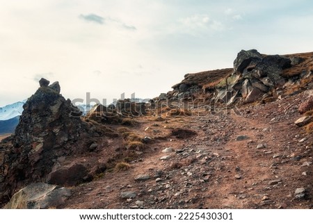 Mountain off-road track to high mountain village in Caucasus region.Dangerous narrow cliffside mountain road through sharp rocks.. Dangerous off road driving along mountain edge and steep cliffs. Royalty-Free Stock Photo #2225430301