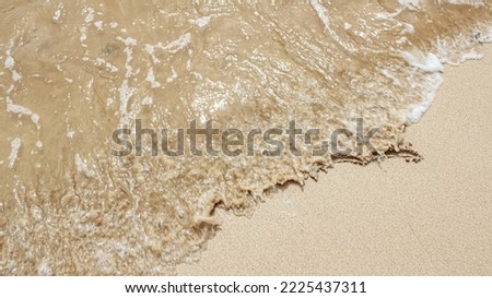 Splashing waves on the beach with beautiful sand. Vacation to the beach in summer. Children's play area.