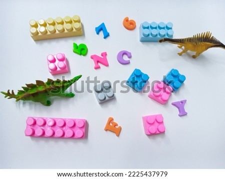 Kid Toys background. Colorful blocks, alphabet toys and Dinosaurs toys frame on white background.
