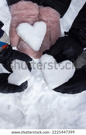 Love Winter. hands of two adults and a child in mittens hold 3 hearts made of snow. Vacation in winter season, active lifestyle. Friendly family. snow games. winter walks. enjoy moment in any weather
