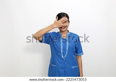 Funny young asian woman standing while laughing and covering her face. Isolated on white background