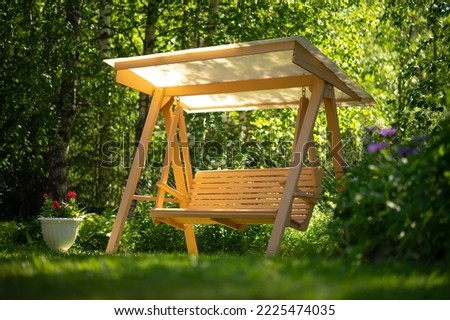 Garden swing with your own hands. Wooden swing for the garden. A place to relax and unwind in the summer garden. Royalty-Free Stock Photo #2225474035