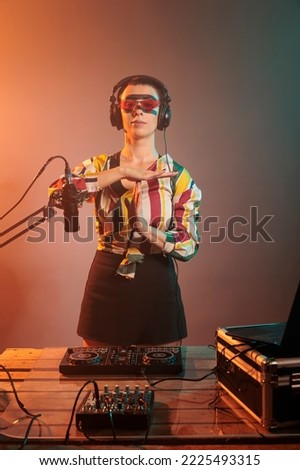 Disc jockey advertising timeout sign with hands, doing t shape symbol and expressing break or stop gesture. Woman DJ feeling tired and asking for pause, exhausted musical artist in studio.