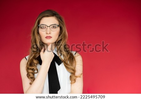 Front portrait of a young woman wearing glasses. Isolated on red background studio shot.