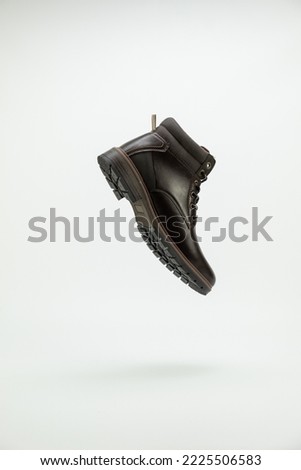 Flying men brown casual style boots over white background. Side view. Copy space for ad, design, text.