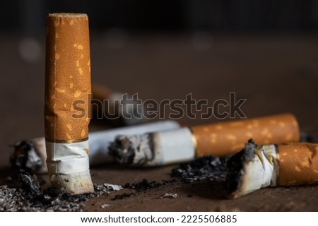 Cigarette butts on rgey background close up.