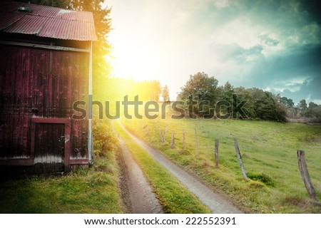 Summer landscape with old barn and country road 