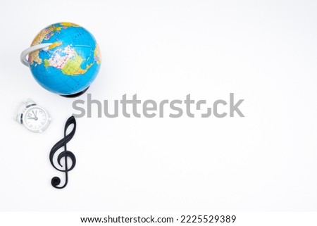 Musical background from treble clef, globe and alarm clock. White empty space.