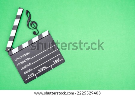 Creative concept find yourself in music. Treble clef, clapperboard, globe on a green background as an idea of creativity without borders.