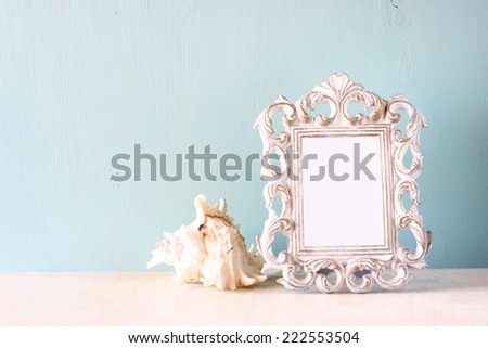 image of vintage antique classical frame and seashell on wooden table