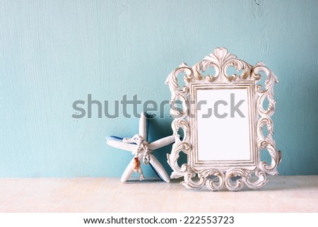 image of vintage antique classical frame and starfish on wooden table
