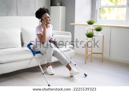 Woman With Leg Injury Using Crutches At Home Royalty-Free Stock Photo #2225539323